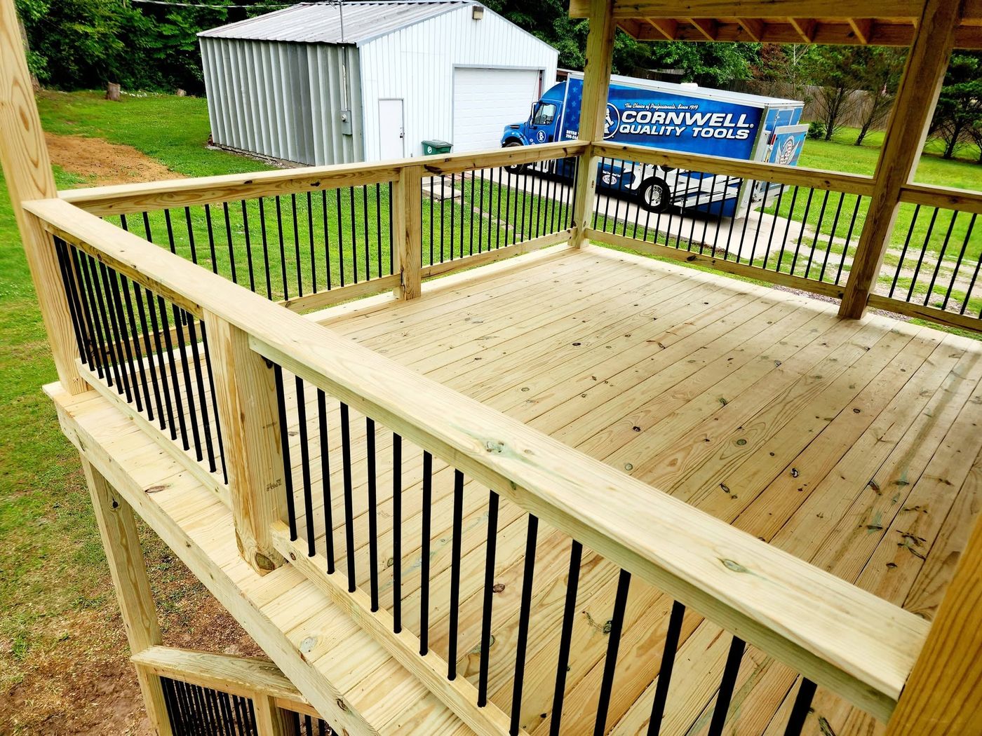 Covered deck floor and railing in pressure-treated pine