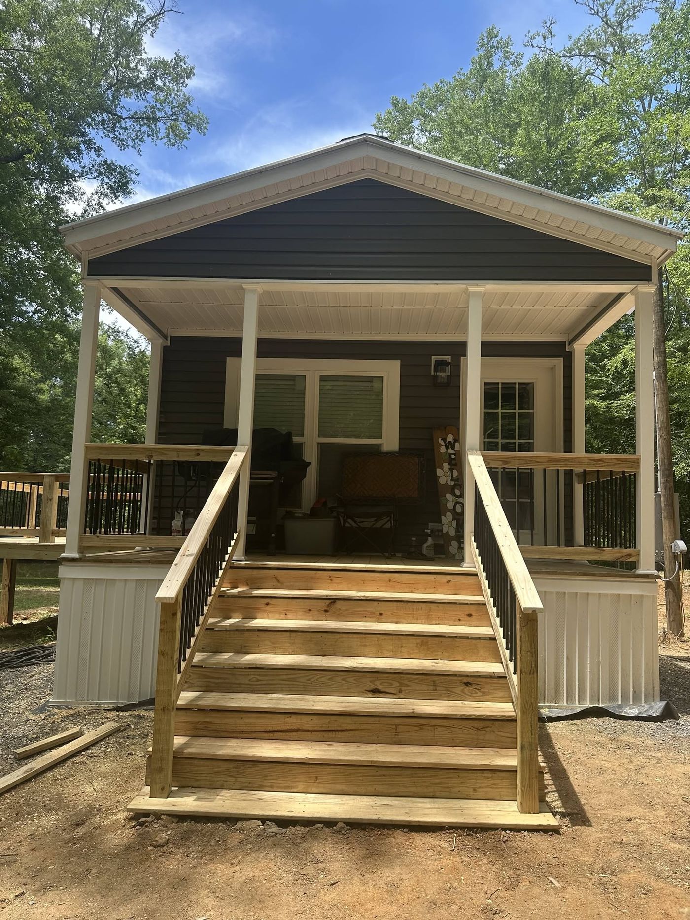 Covered front porch with gable roof and wood stairs built by Pack's
