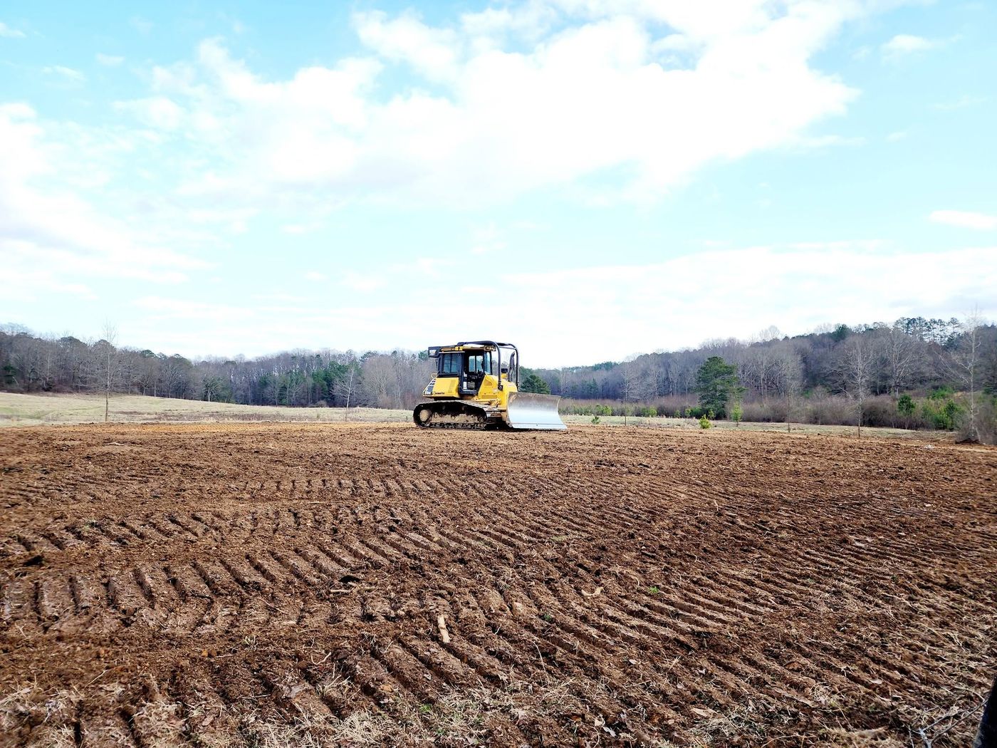 Komatsu dozer grading a cleared field