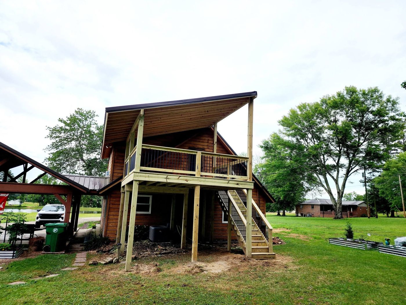 Elevated covered deck with black balusters built onto a cabin