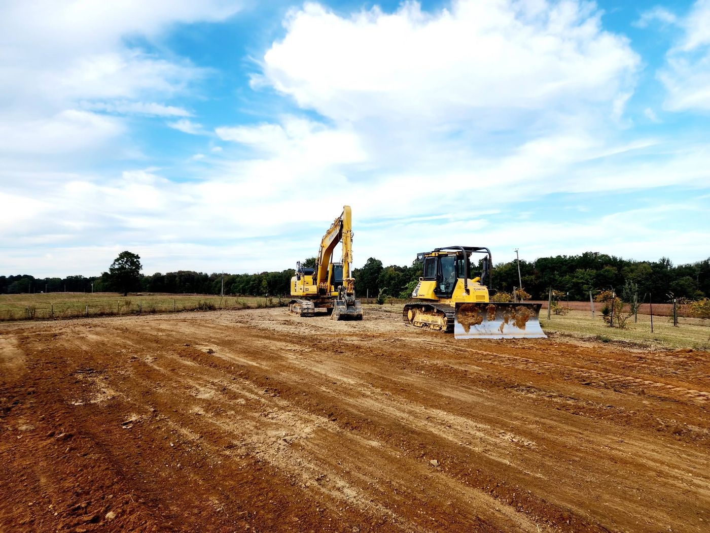 Excavator and dozer finishing a farm pad
