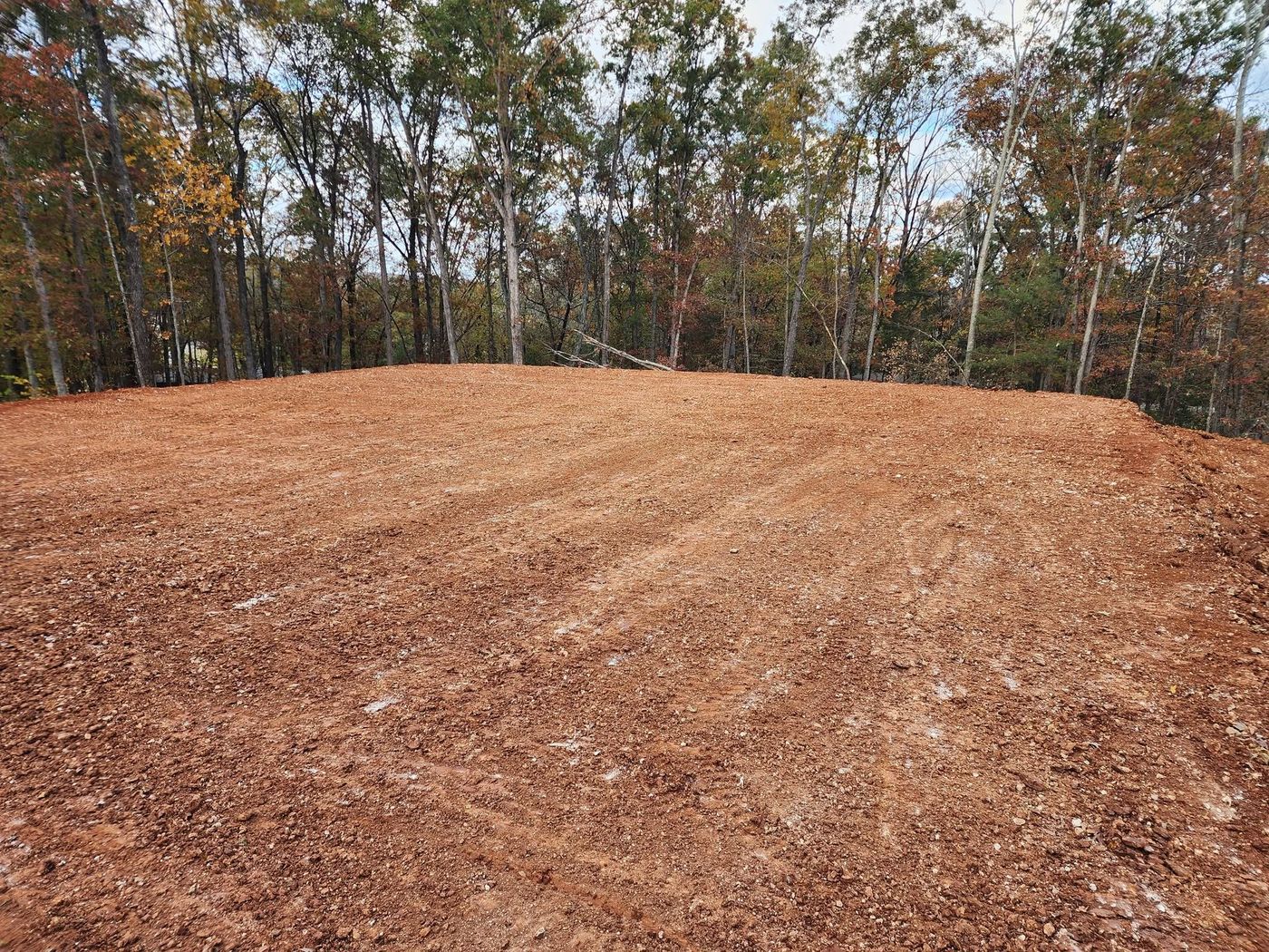 Finished compacted red-clay house pad in a wooded lot