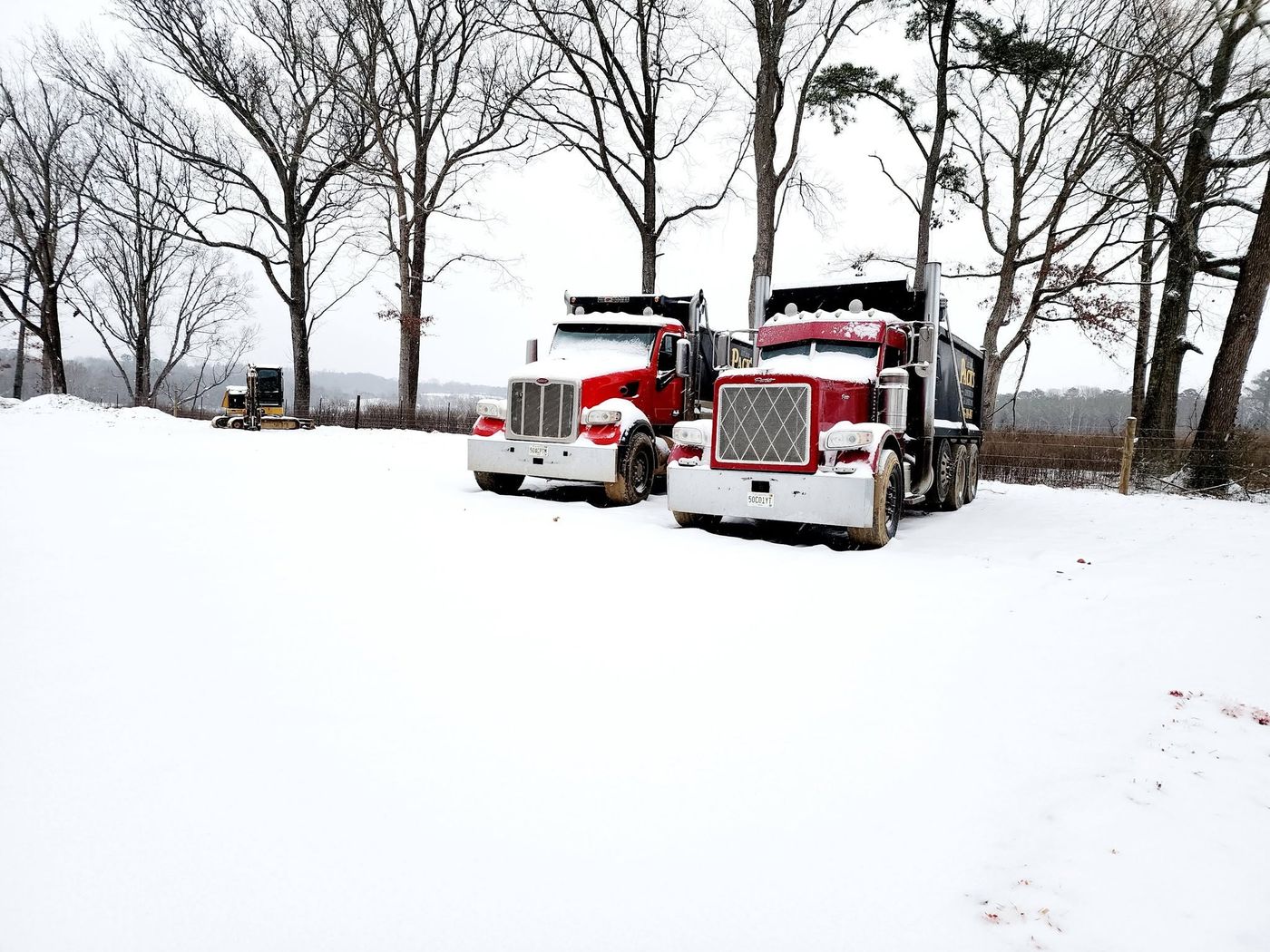 Two Pack's dump trucks parked in snow