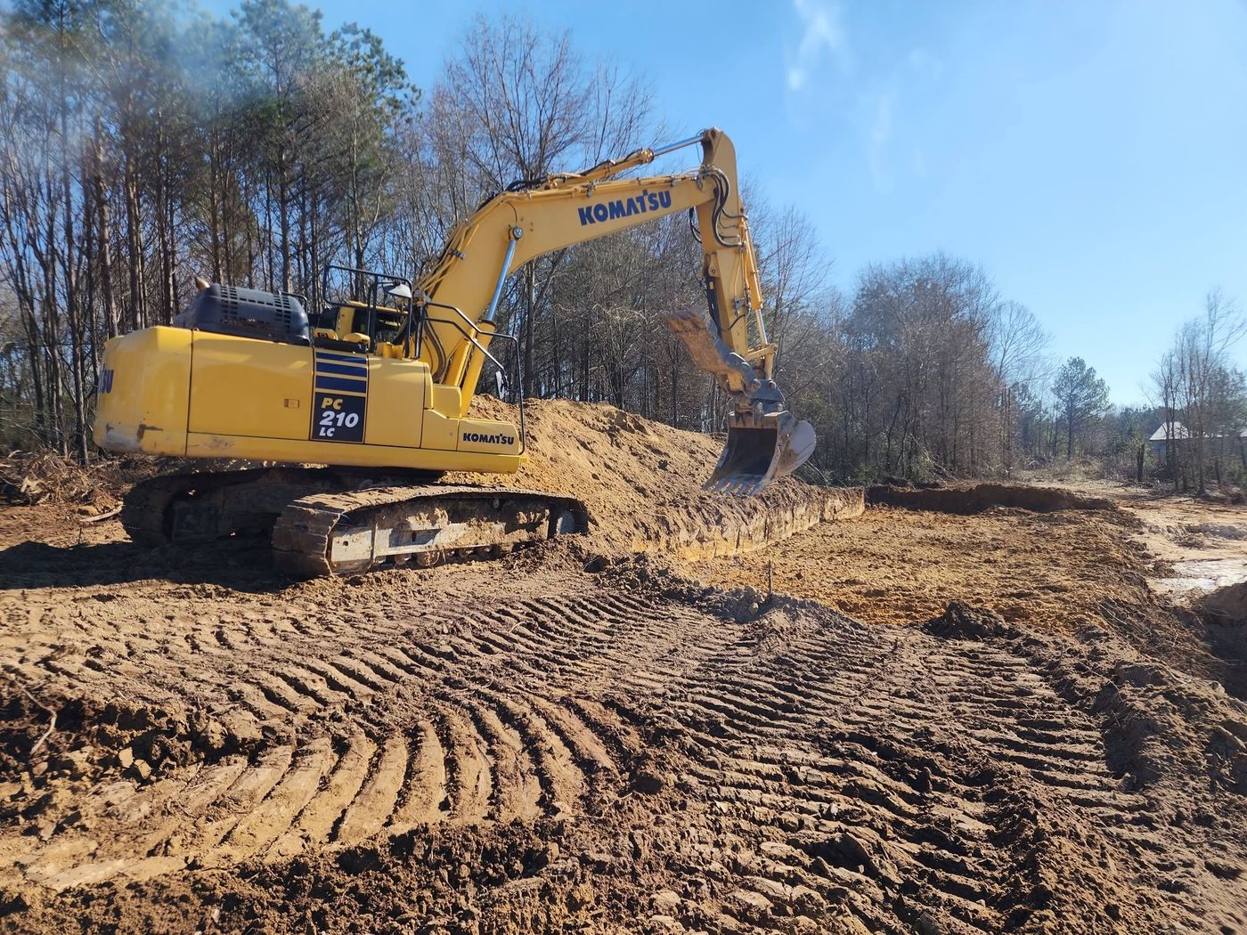 Komatsu PC210 excavator digging on a Pack's site prep job