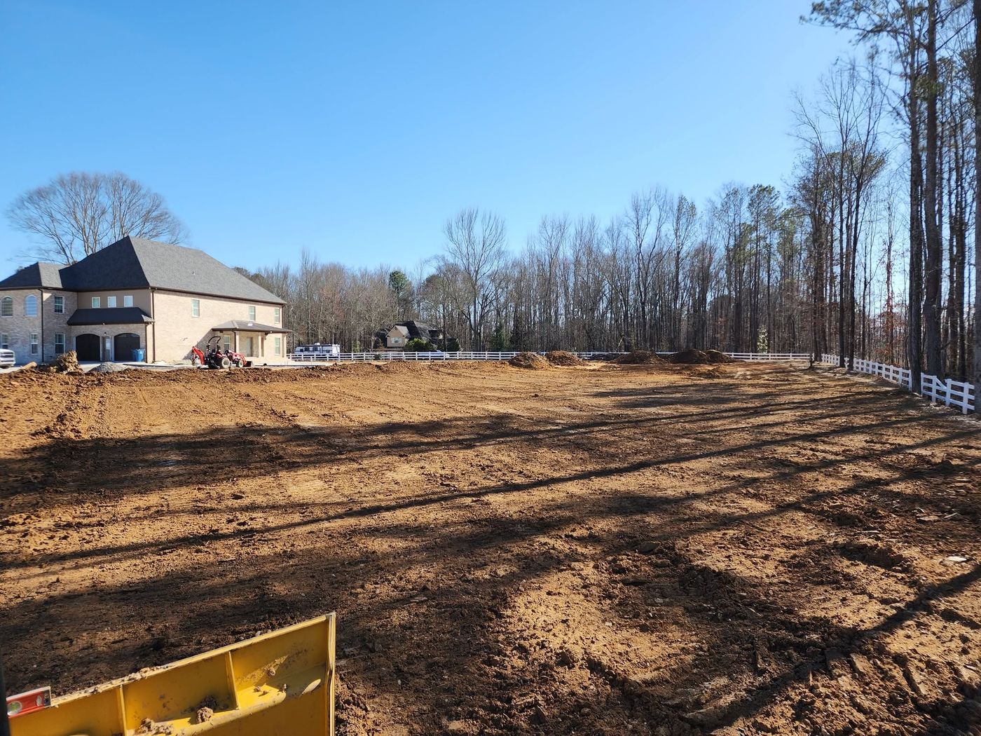Residential lot graded smooth beside a new brick home